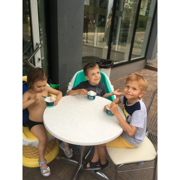 Egor tasting a coconut ice-cream with his friends in the cafe “33 penguins”, Sochi, 2019
