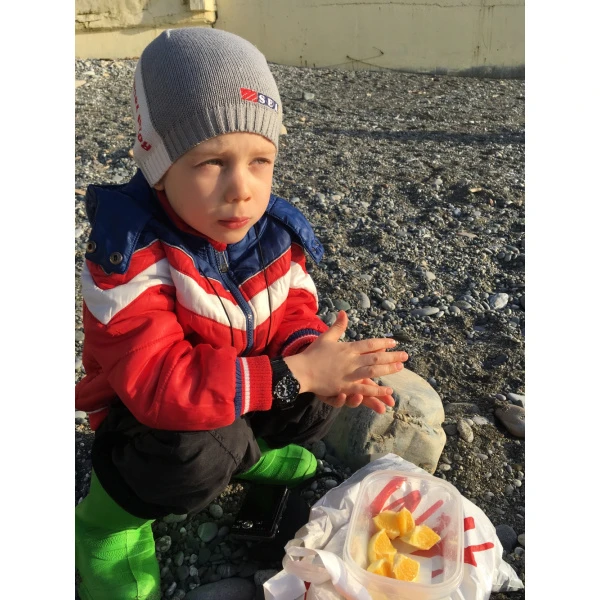 Enjoying juicy orange at the seaside, Sochi, 2019